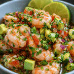 Chilli Lime Shrimp Ceviche with avocado, tomato, red onion, and fresh cilantro in a glass bowl