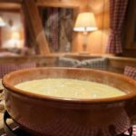 cheese fondue recipe in ceramic pot with bread cubes