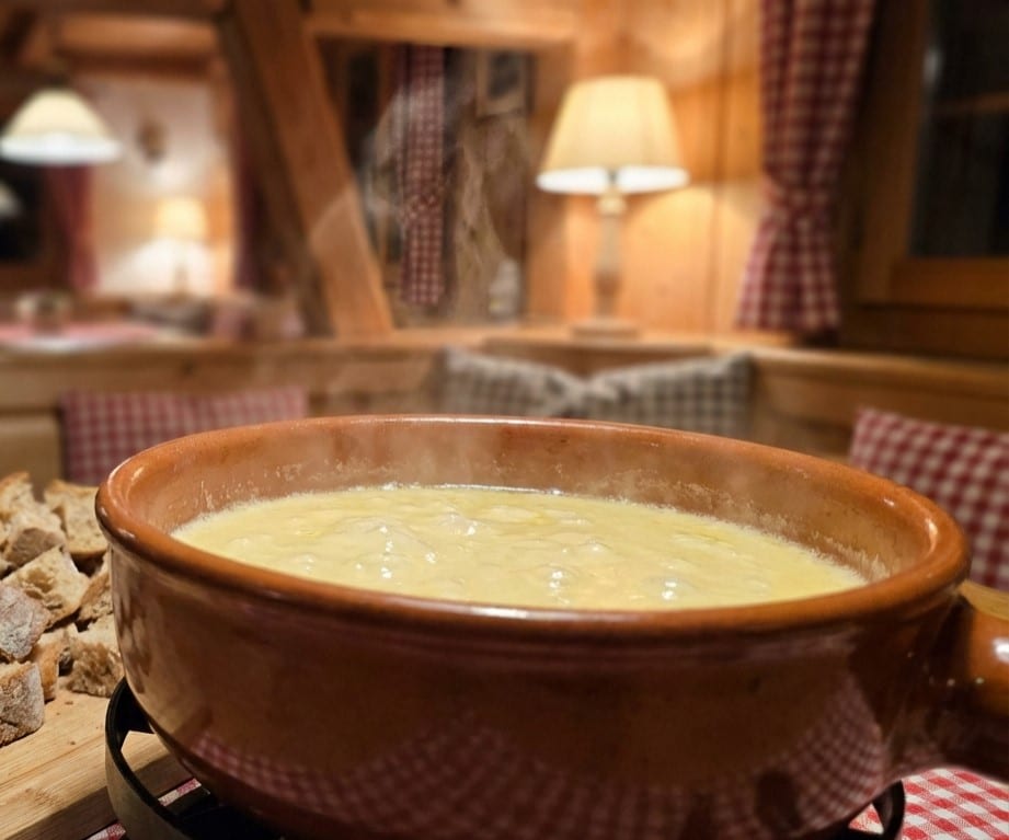 cheese fondue recipe in ceramic pot with bread cubes