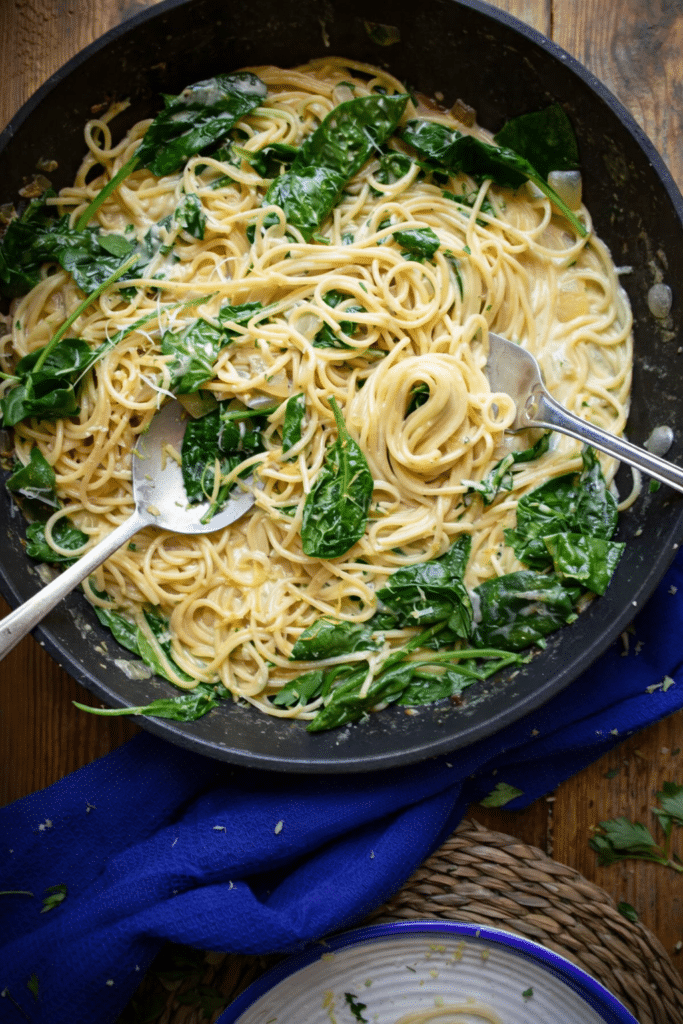 Fresh Spinach & Lemon Spaghetti served in a bowl with creamy lemon sauce, parmesan cheese, and wilted spinach