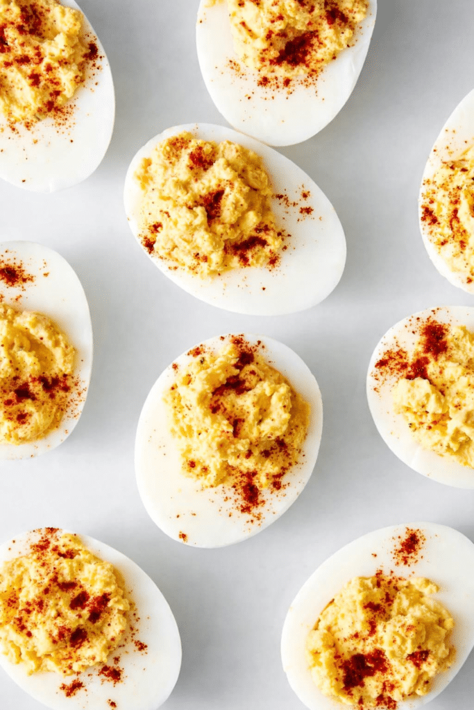 Easy deviled eggs with creamy yolk filling and paprika garnish on a serving platter