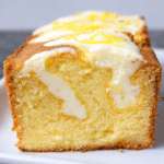Fresh lemon cream cheese loaf sliced on a wooden board with lemon glaze drizzle