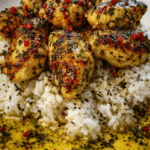 Close-up of creamy garlic Parmesan rice topped with tender chicken scampi and lemon garlic sauce