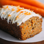 Quick carrot cake banana bread loaf sliced on a wooden board showing moist texture with shredded carrots and ripe bananas.